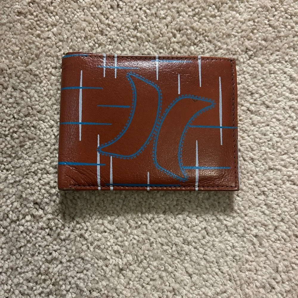 Hurly men's bifold leather wallet with a hands-up logo and nomad print inlay